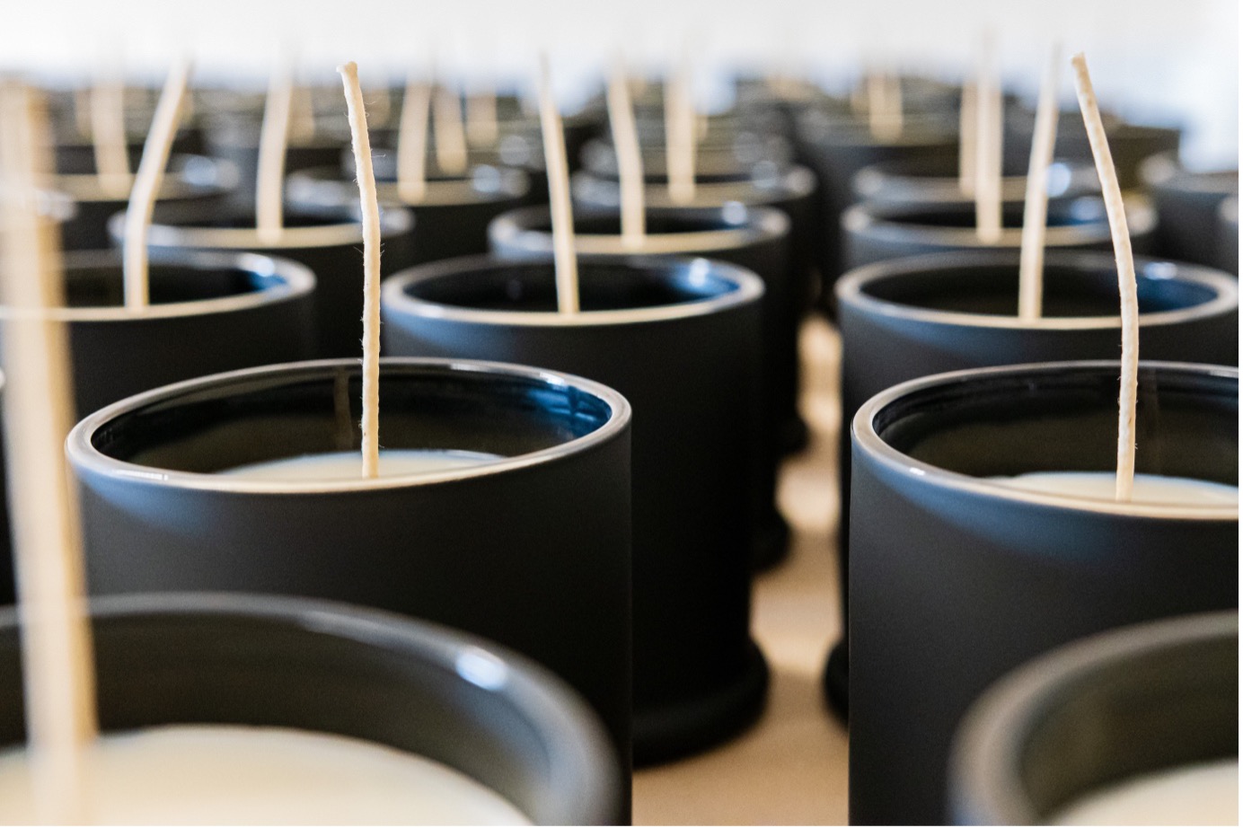 Candles lined up ready to have their wicks trimmed to size.